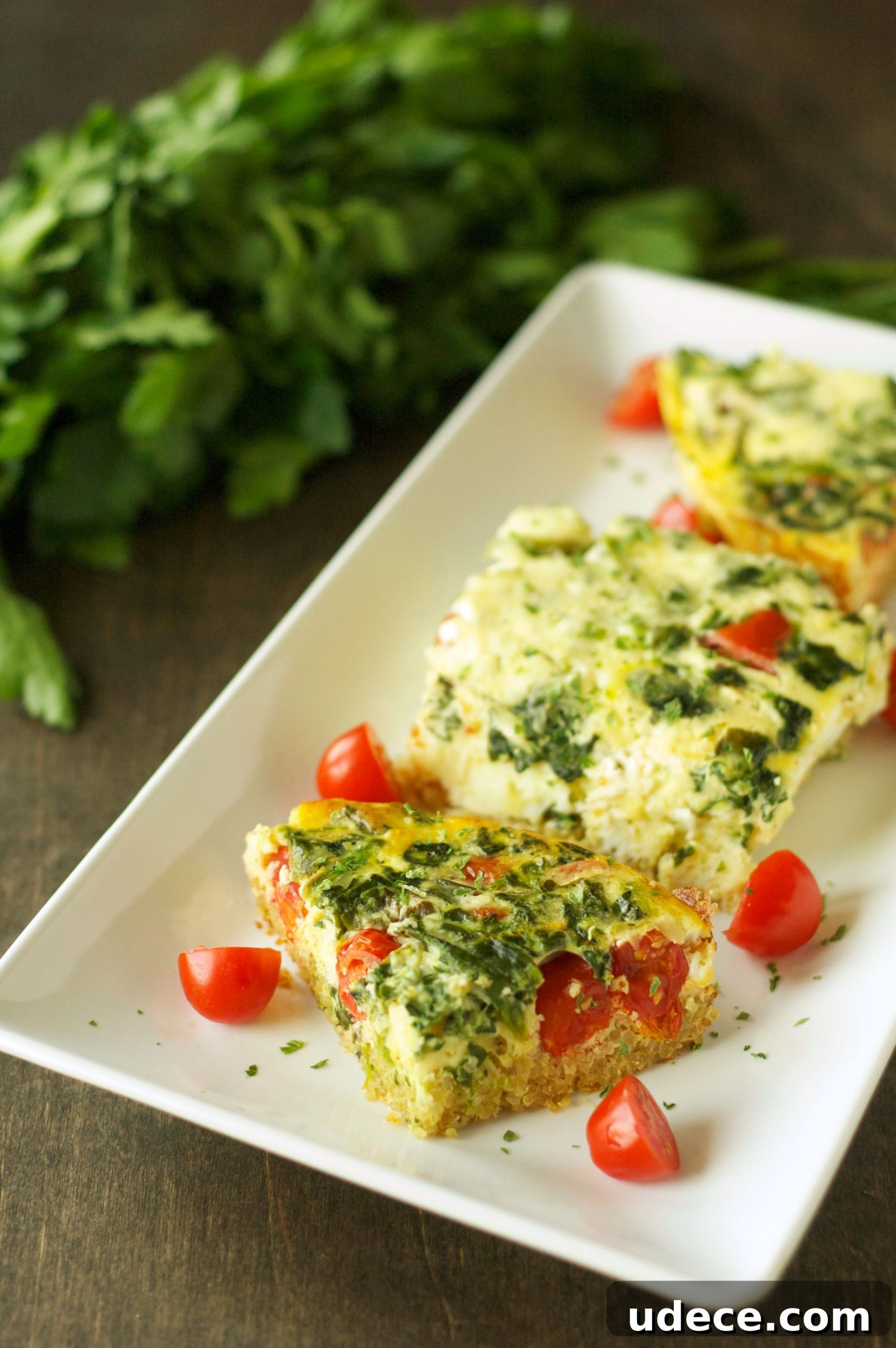 Three pieces of breakfast casserole on white oblong plate 