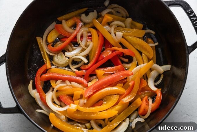 Italian Sausage with Peppers & Onions in Savory Tomato Sauce 4 Sliced peppers and onions in a deep cast iron skillet.
