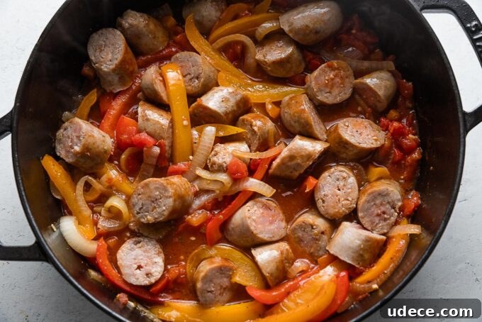 Italian Sausage with Peppers & Onions in Savory Tomato Sauce 6 Sliced Italian sausages with peppers and onions in a light tomato sauce simmering in a deep cast iron skillet.
