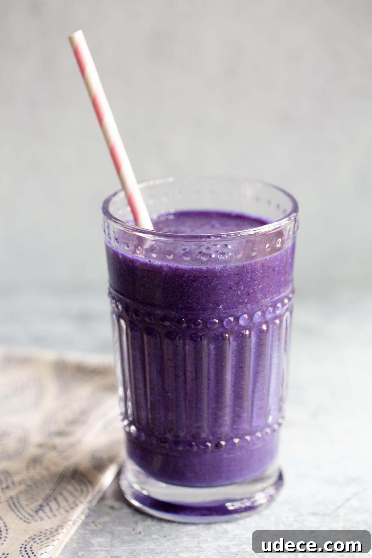 Blue Spirulina Smoothie Recipe for Energy and Glow 6 spirulina smoothie in a glass with a pink and white straw
