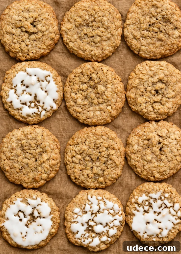 Overhead view of plain and iced oatmeal cookies in rows on a linen cloth.