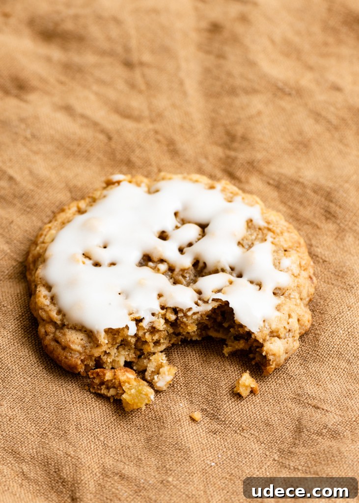 Closeup of an iced oatmeal cookie with a bite missing out of the side.