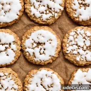 Overhead view of iced oatmeal cookies in rows on a linen cloth.