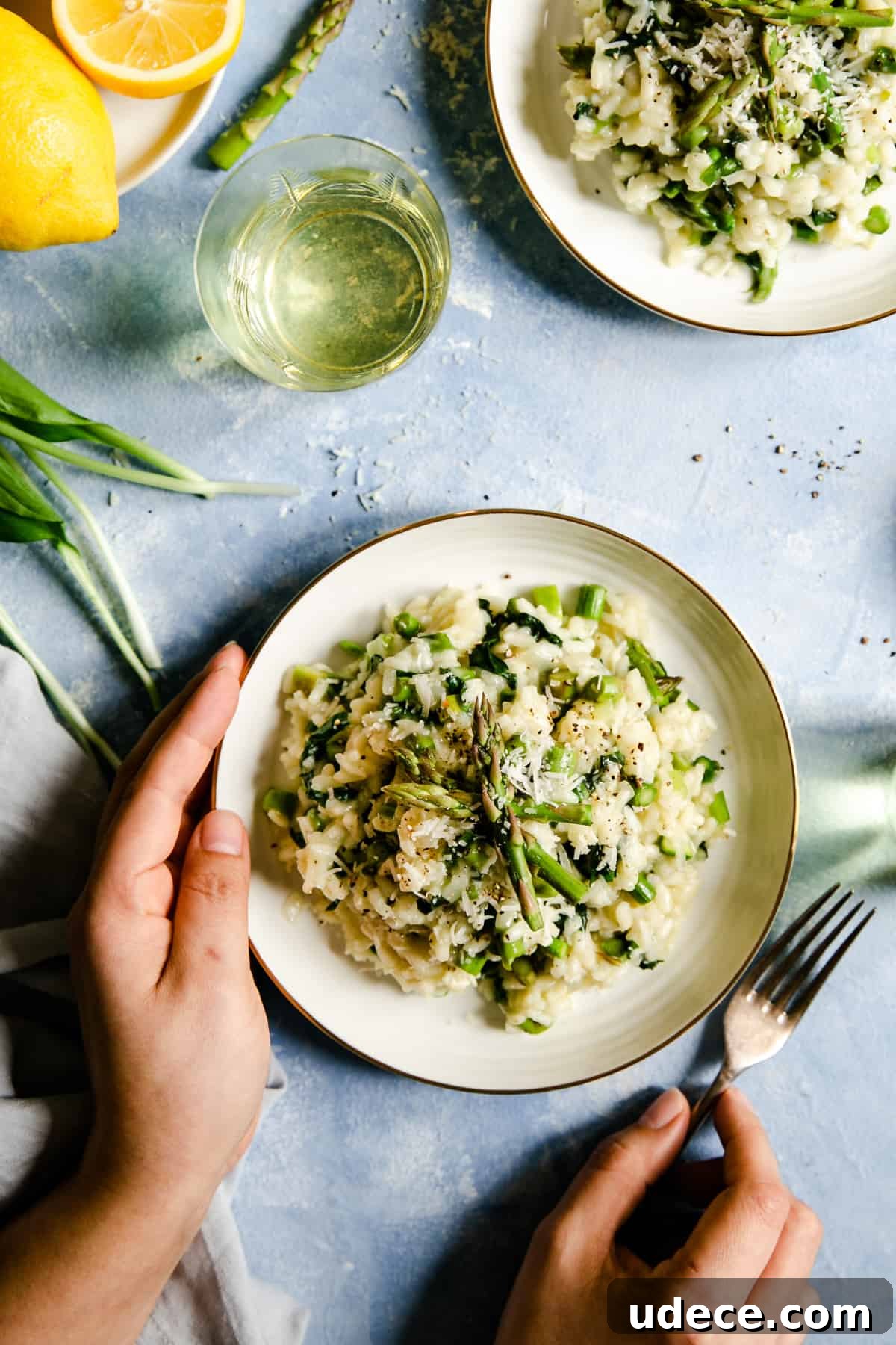 overhead shot of person holding a bowl with wild garlic and asparagus risotto 