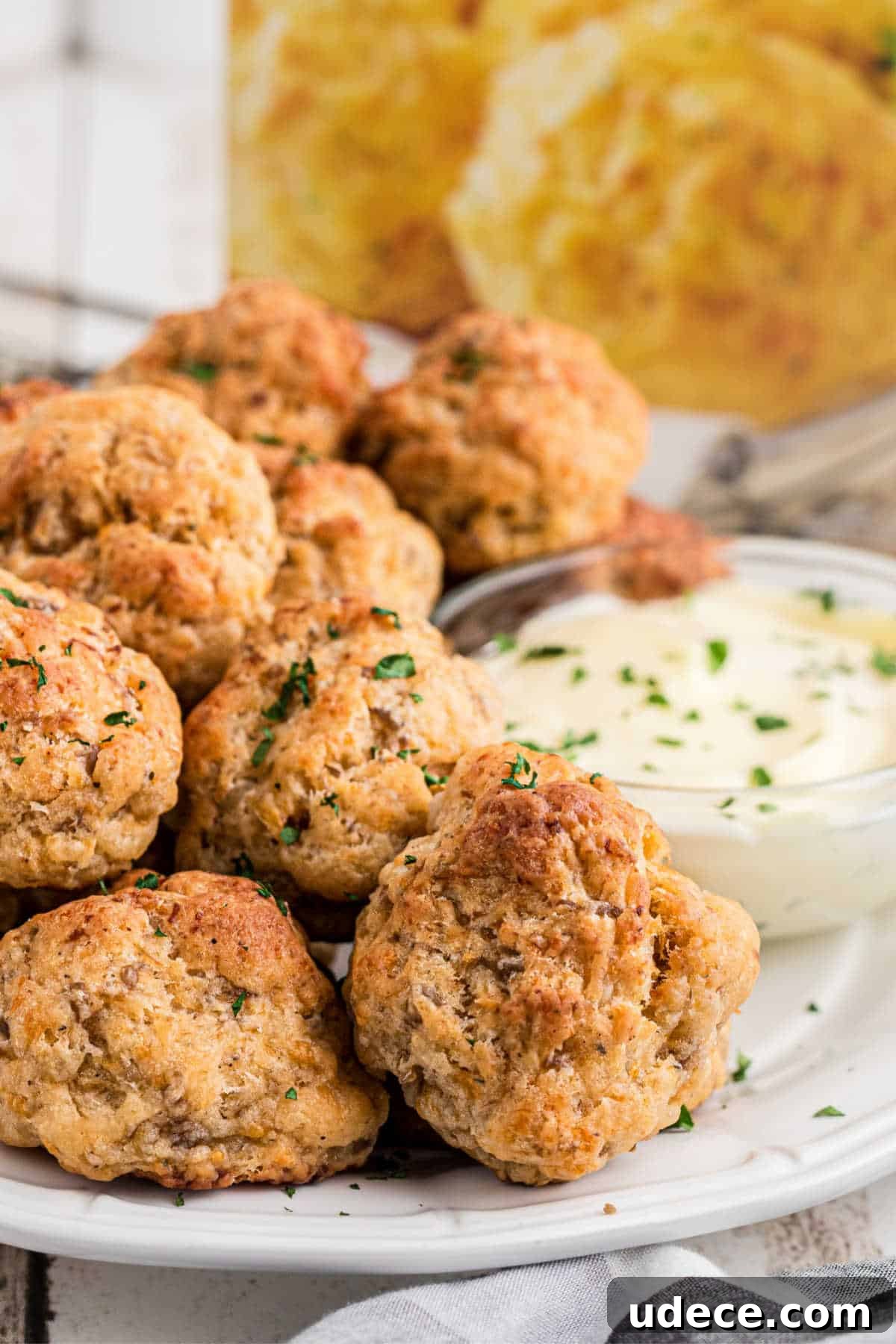 Cheddar Bay-Style Sausage Balls Recipe for Parties and Snacks 2 Side angled shot of a plate full of cheddar bay sausage balls.