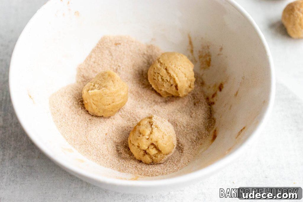Edible Snickerdoodle Cookie Dough Recipe 8 balls being rolled in cinnamon sugar in bowl