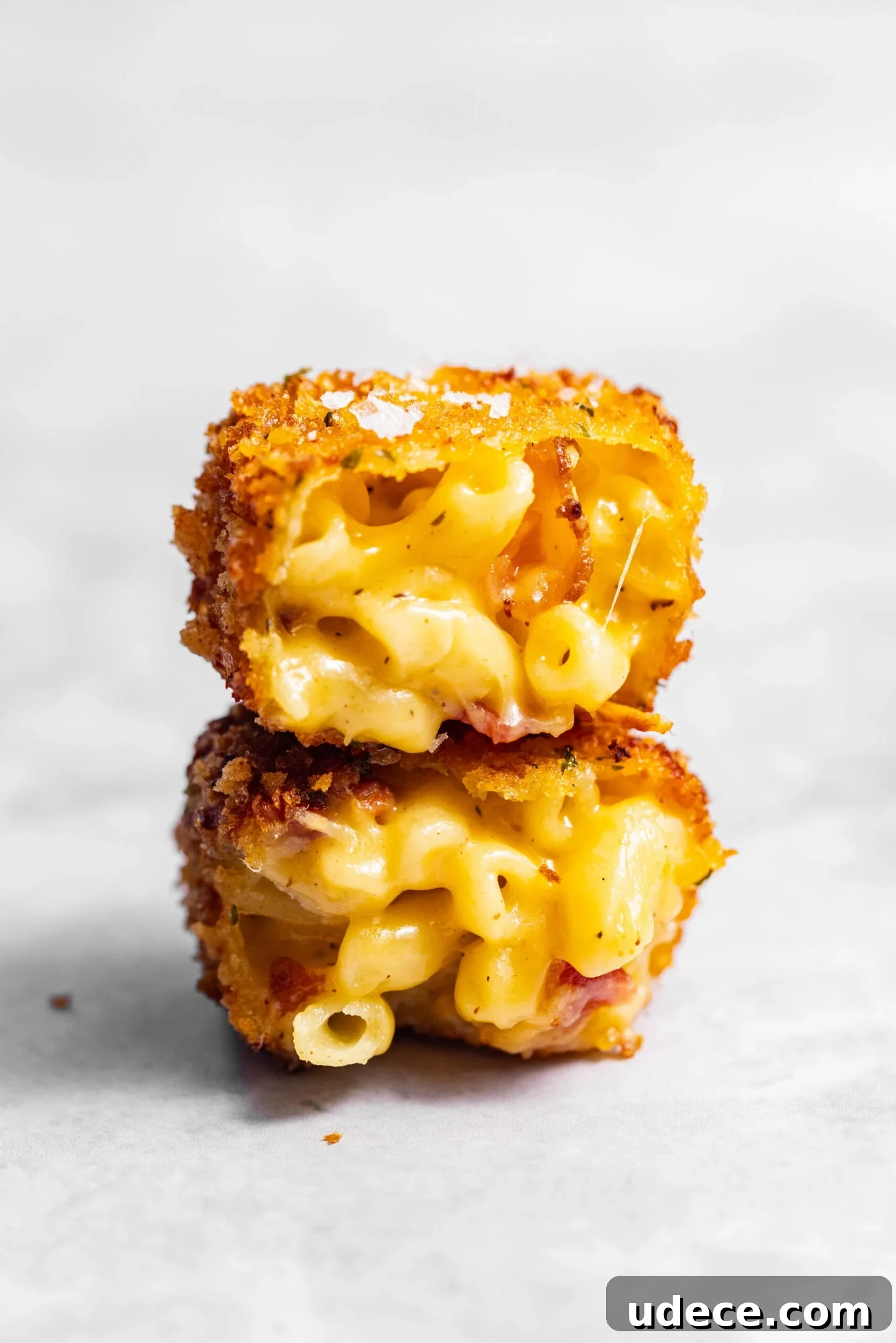 Crispy Homemade Mac and Cheese Bites: Bite-Sized Comfort Food 2 Crispy Fried Homemade Mac and Cheese Bite cut in half and stacked on top of each other.