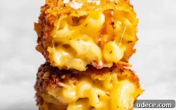 Crispy Homemade Mac and Cheese Bites: Bite-Sized Comfort Food 14 Crispy Fried Homemade Mac and Cheese Bite cut in half and stacked on top of each other.