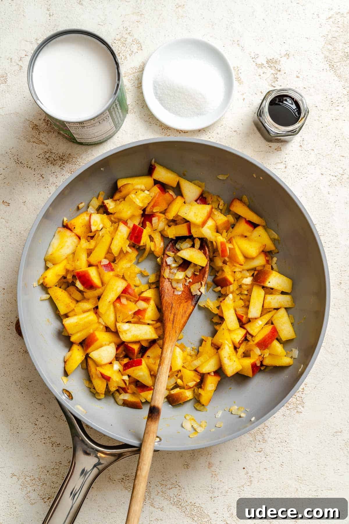 Creamy Apple Curry Recipe with Warm Spices and Coconut Milk 6 Process shot showing ingredients cooking on pan.