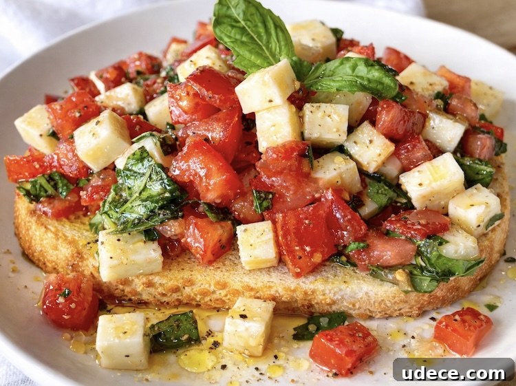 Chopped Caprese Toast: Fresh Tomato, Basil & Mozzarella Recipe 7 Close up view of delicious caprese toast a vegetarian lunch or dinner made with fresh tomatoes, basil, and mozzarella cheese.