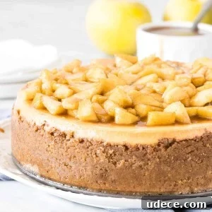 Caramel Apple Cheesecake Recipe with Crunchy Streusel Topping 6 Round cheesecake topped with chopped cinnamon apples on a plate.