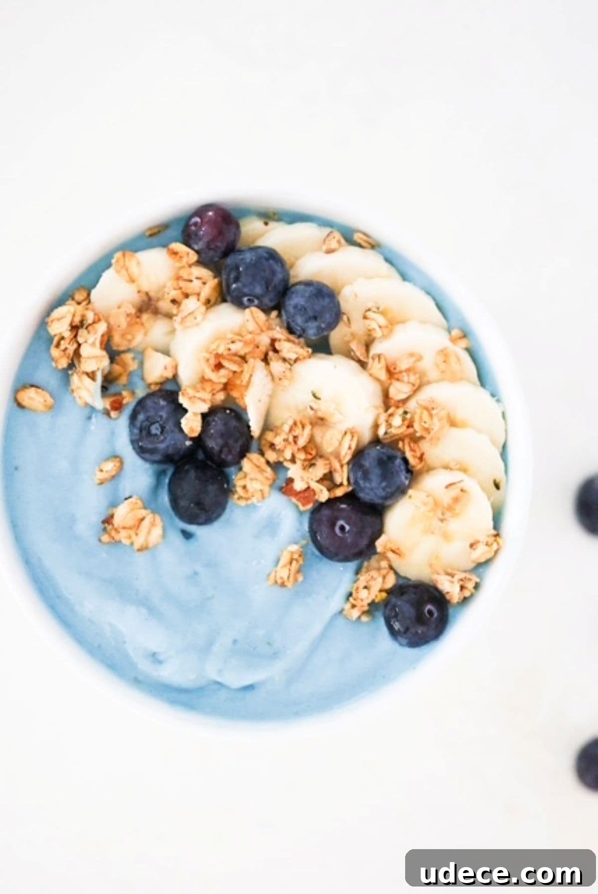 Vibrant Blue Spirulina Smoothie Bowl Recipe for Instagram-Worthy Breakfast 2 Blue smoothie bowl topped with banana slices, blueberries, and granola.