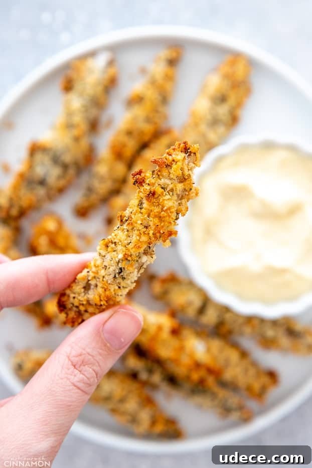 baked portobello mushrooms a hand holding a healthy baked portobello mushroom fry over a plate
