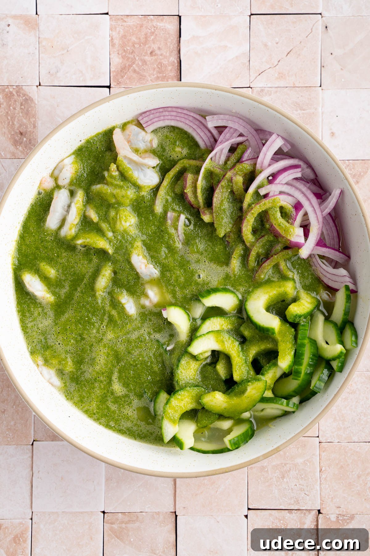 Aguachile de Camarón: Spicy Mexican Shrimp Recipe 7 The green sauce in the bowl with the shrimp, red onion, and cucumber.