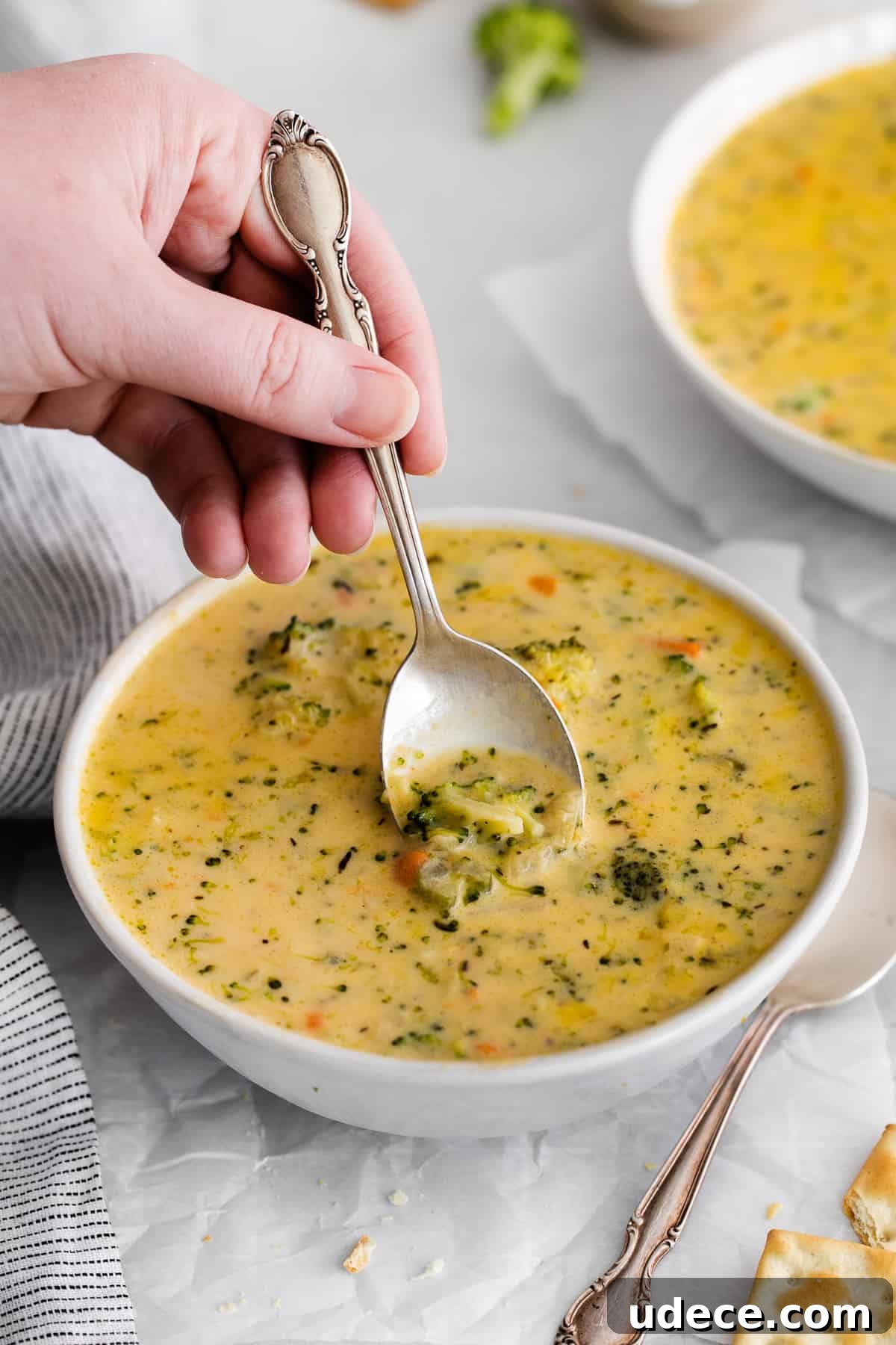 Creamy Broccoli, Potato & Cheddar Soup Recipe 6 A spoon scooping a spoonful of soup.