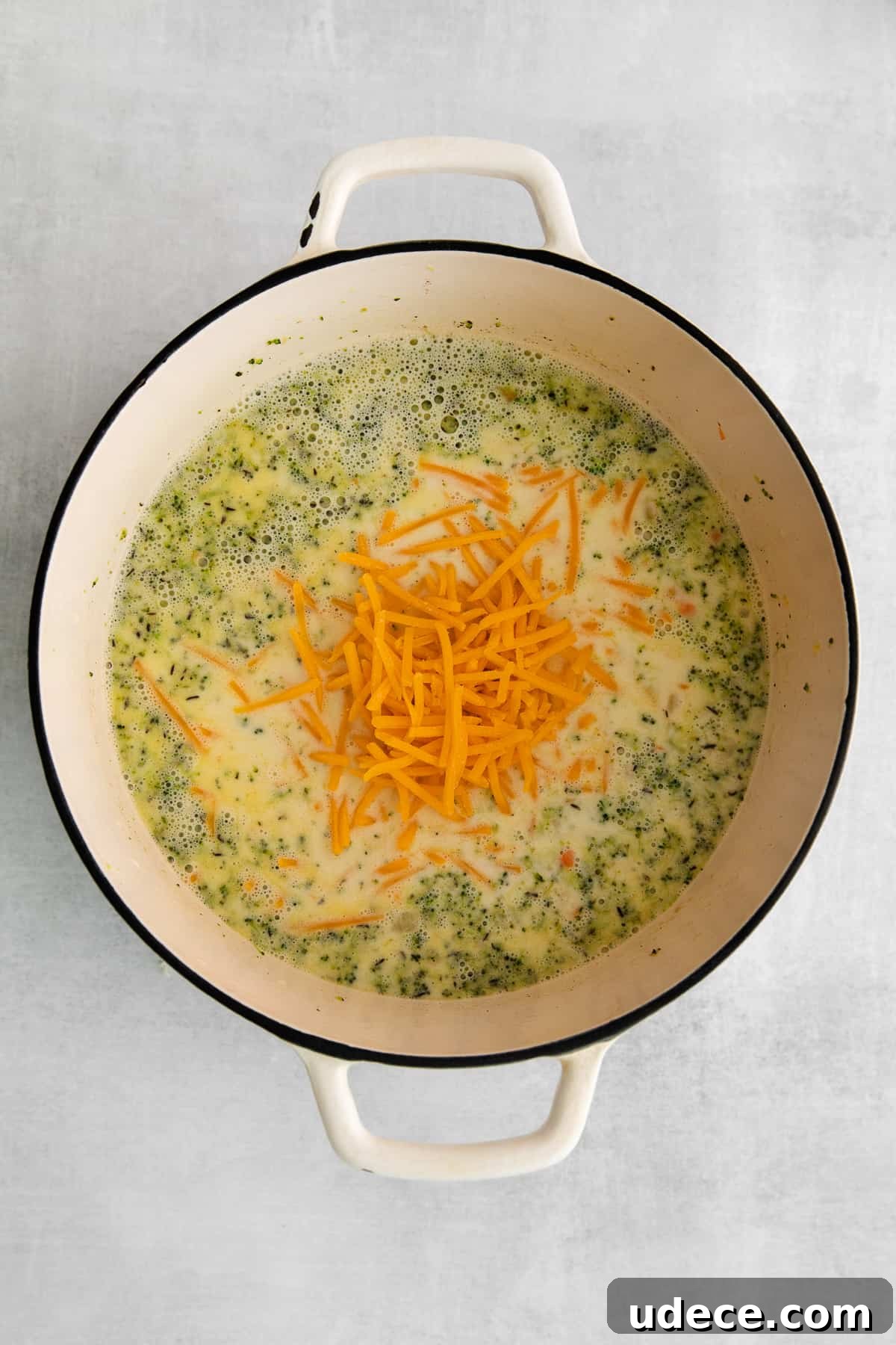Creamy Broccoli, Potato & Cheddar Soup Recipe 5 Adding cheddar cheese to the soup.