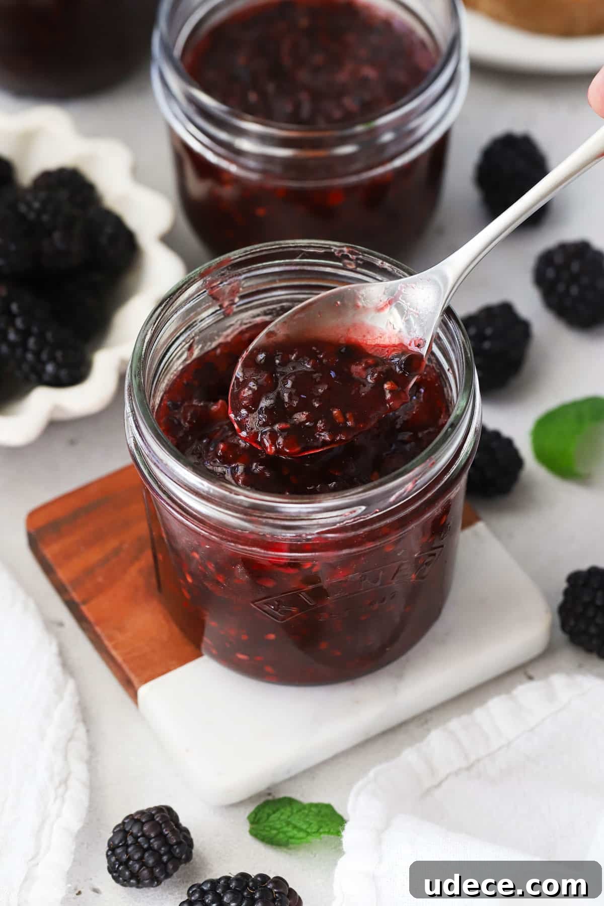 Blackberry Freezer Jam Recipe: Quick No-Cook Preserve 8 Spoon scooping blackberry freezer jam out of the jar