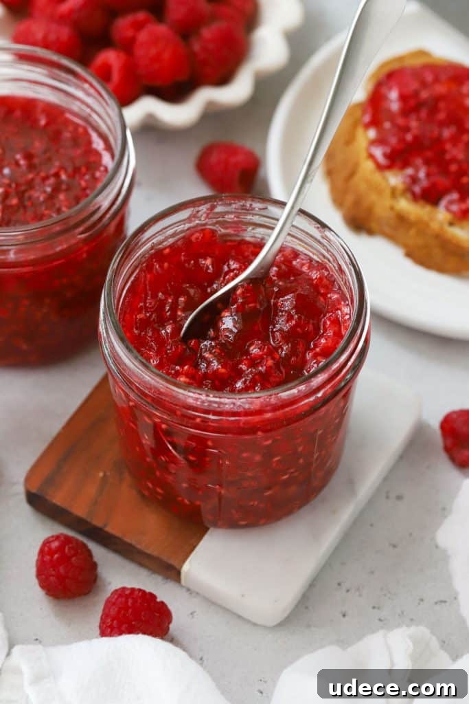 Blackberry Freezer Jam Recipe: Quick No-Cook Preserve 9 Scooping raspberry freezer jam out of a jar