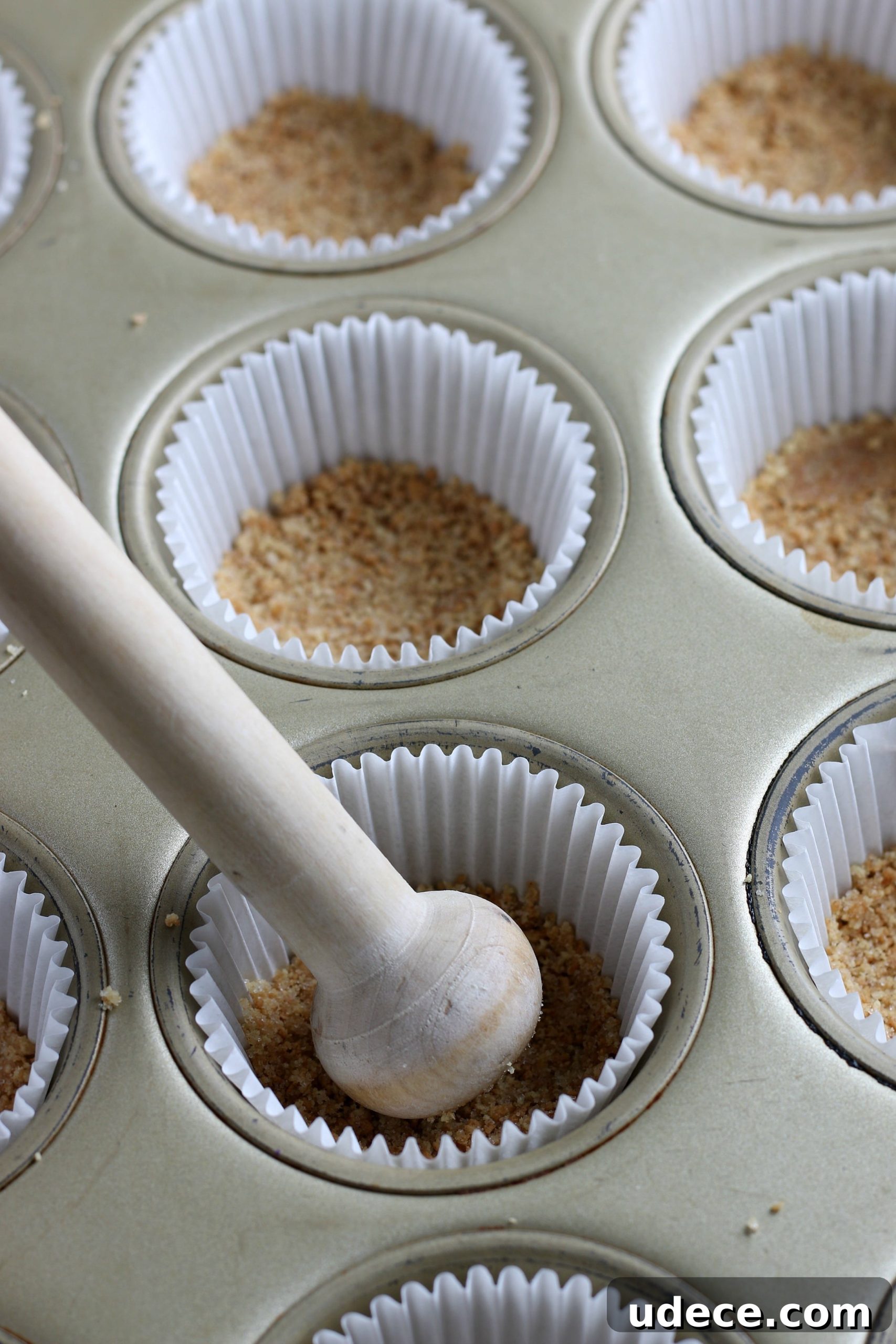 S’mores Cupcakes from Cake Mix: Quick Campfire Dessert Recipe 5 tart shaper pressing graham cracker crust into cupcake liners.