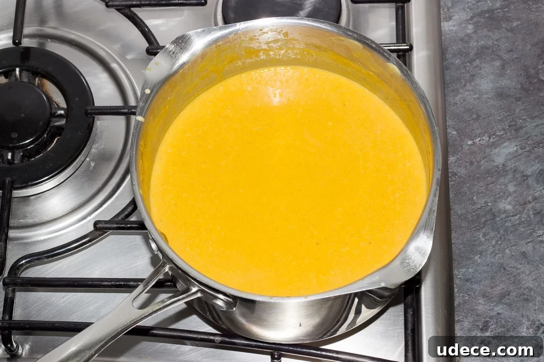 Curried Coconut Lentil Soup with Warm Spices Recipe 11 pureed curried coconut lentil soup simmering in a large pot on the hob