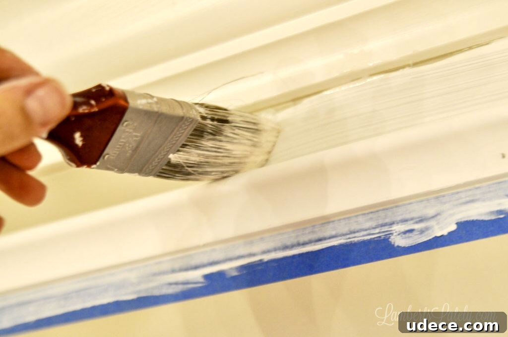DIY Faux Crown Molding Guide: Simple Beginner-Friendly Hack 12 brushing paint onto gap between two pieces of molding.