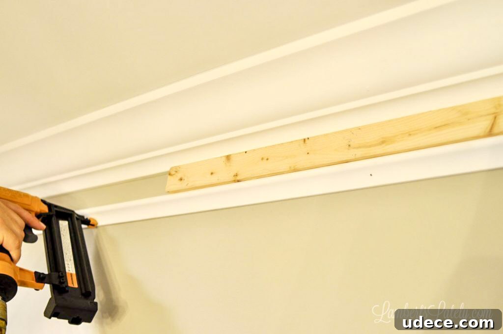 DIY Faux Crown Molding Guide: Simple Beginner-Friendly Hack 6 Using a 1x2 wood spacer to install DIY faux crown molding.