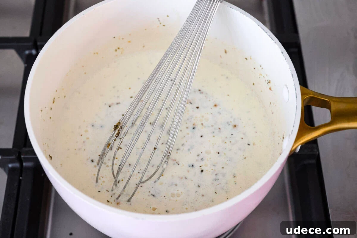 Creamy Baked Chicken Alfredo Pasta Casserole Recipe 3 Sauce ingredients in a saucepan.
