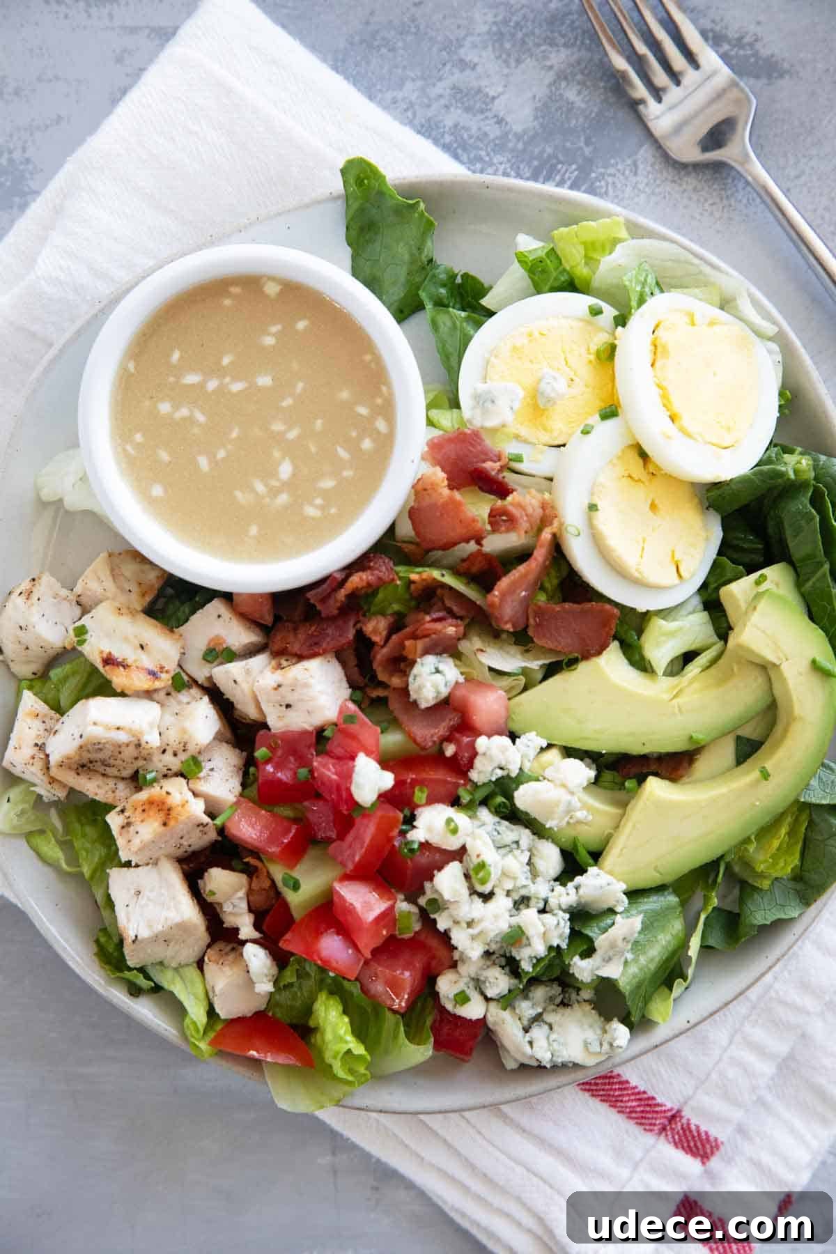 Classic Cobb Salad Recipe with Chicken, Bacon & Avocado 5 Cobb Salad serving on a plate with homemade dressing.