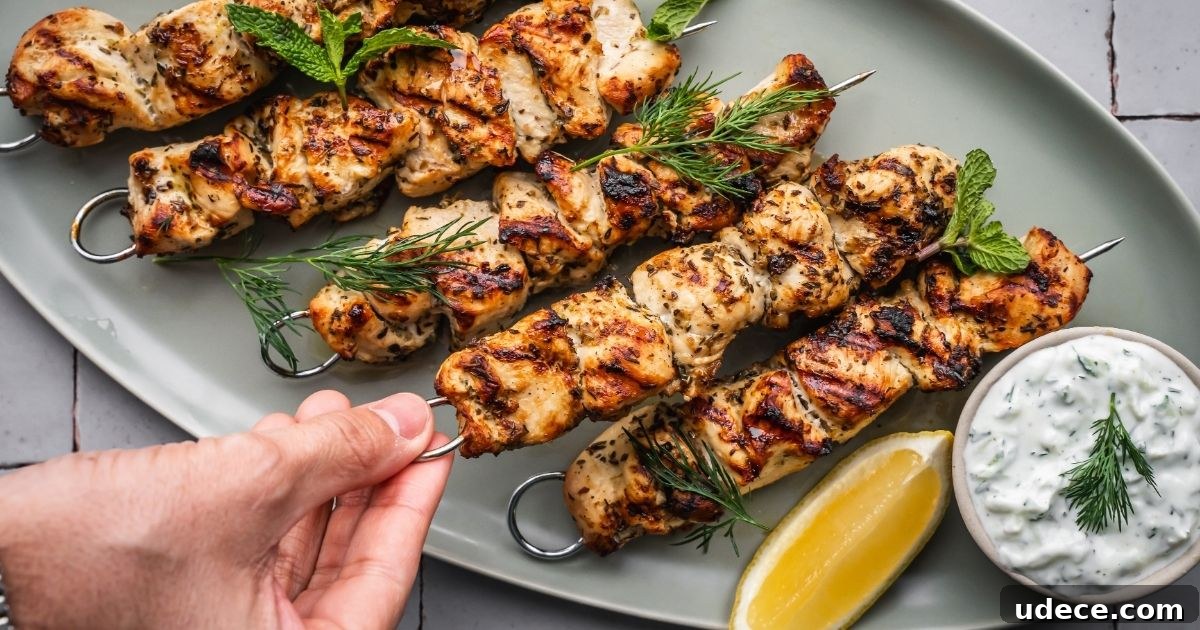 4 Mediterranean Meal Plans for Seasonal August Eating 2 Grilled chicken skewers on a platter with a yogurt sauce on the side and lemon wedge garnish.