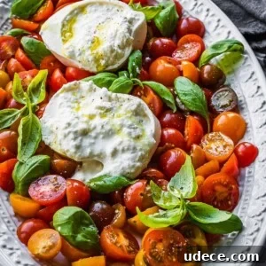 4 Mediterranean Meal Plans for Seasonal August Eating 3 Sliced cherry tomatoes, with basil leaves and an open ball of burrata cheese.