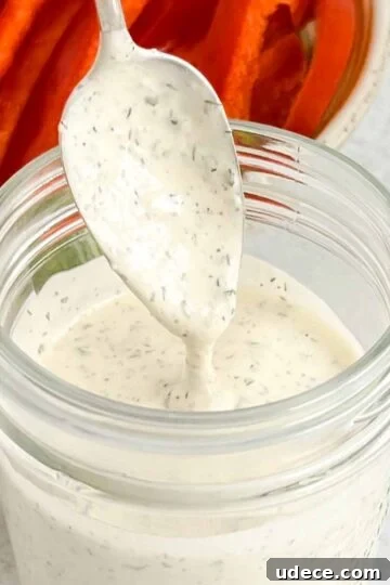 Spoon dripping with ranch dressing.