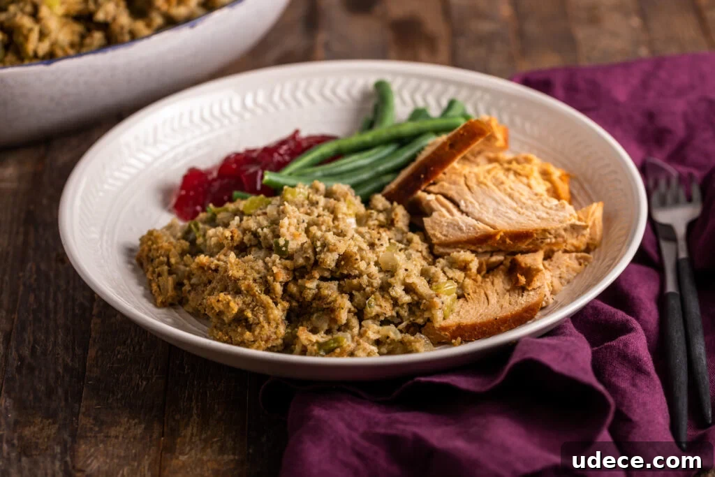 Southern-Style Cornbread Dressing Recipe for Holidays 2 cornbread dressing on a plate with turkey, green beans, and cranberry sauce