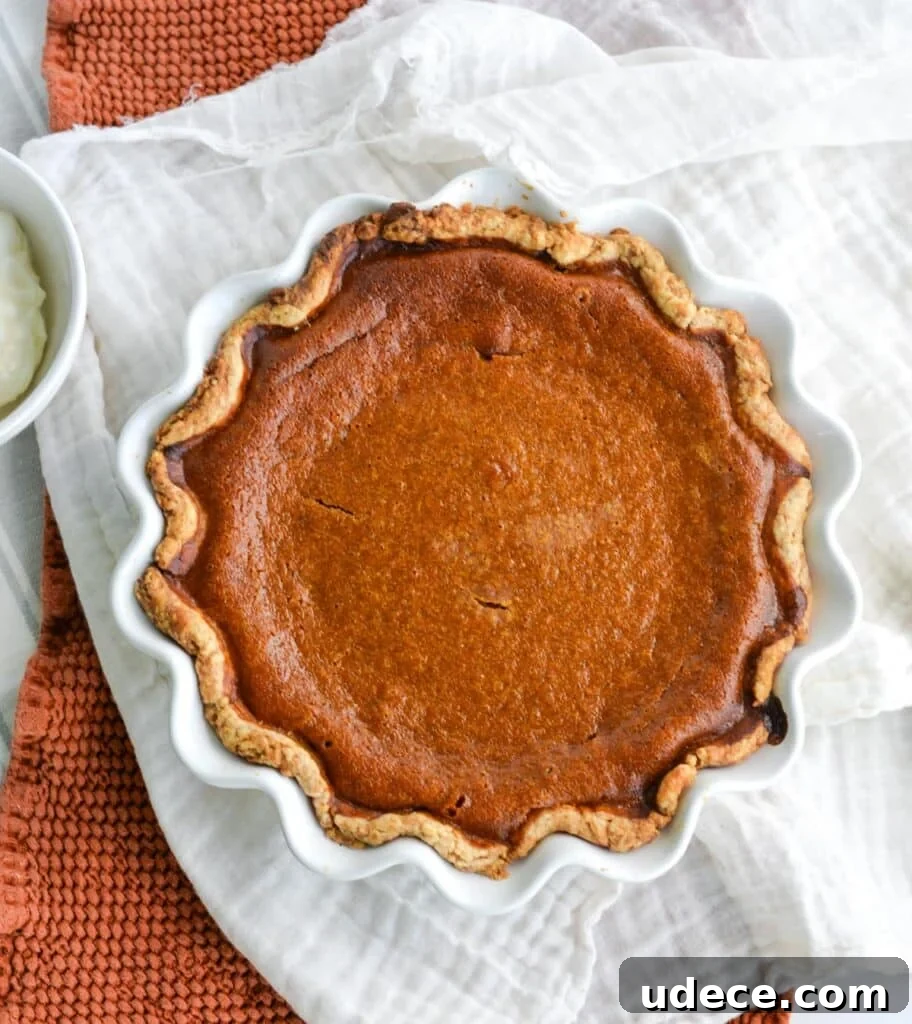 Sourdough Pumpkin Pie Recipe: Flaky Crust with Spiced Filling 12 A whole baked pumpkin pie sitting on a kitchen towel.
