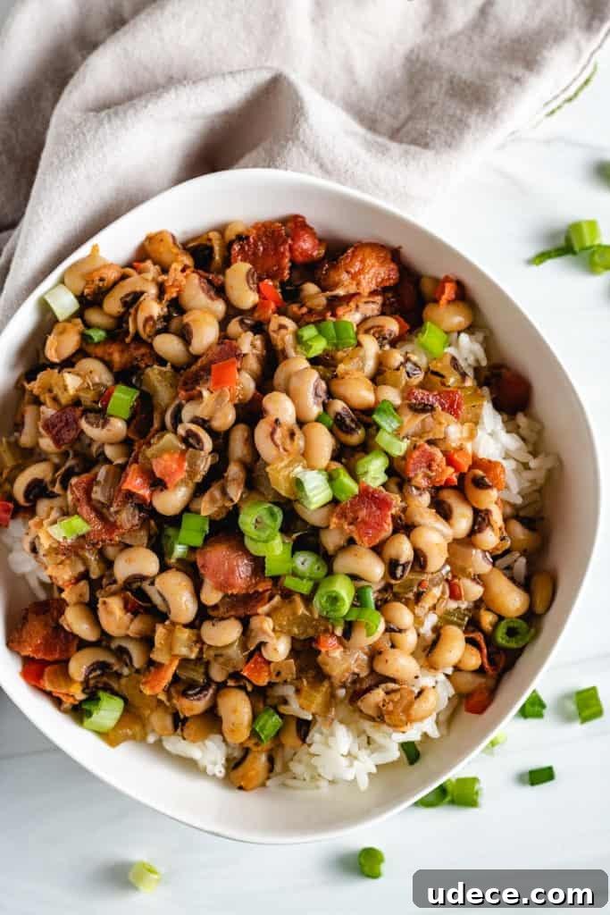 Classic Hoppin' John Recipe: Southern New Year Black-Eyed Peas 2 Top down view of a bowl of hoppin' john over rice.