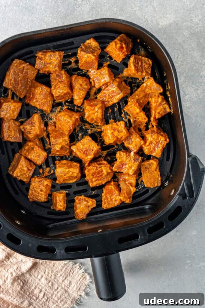 Marinated bang bang salmon in the air fryer basket.