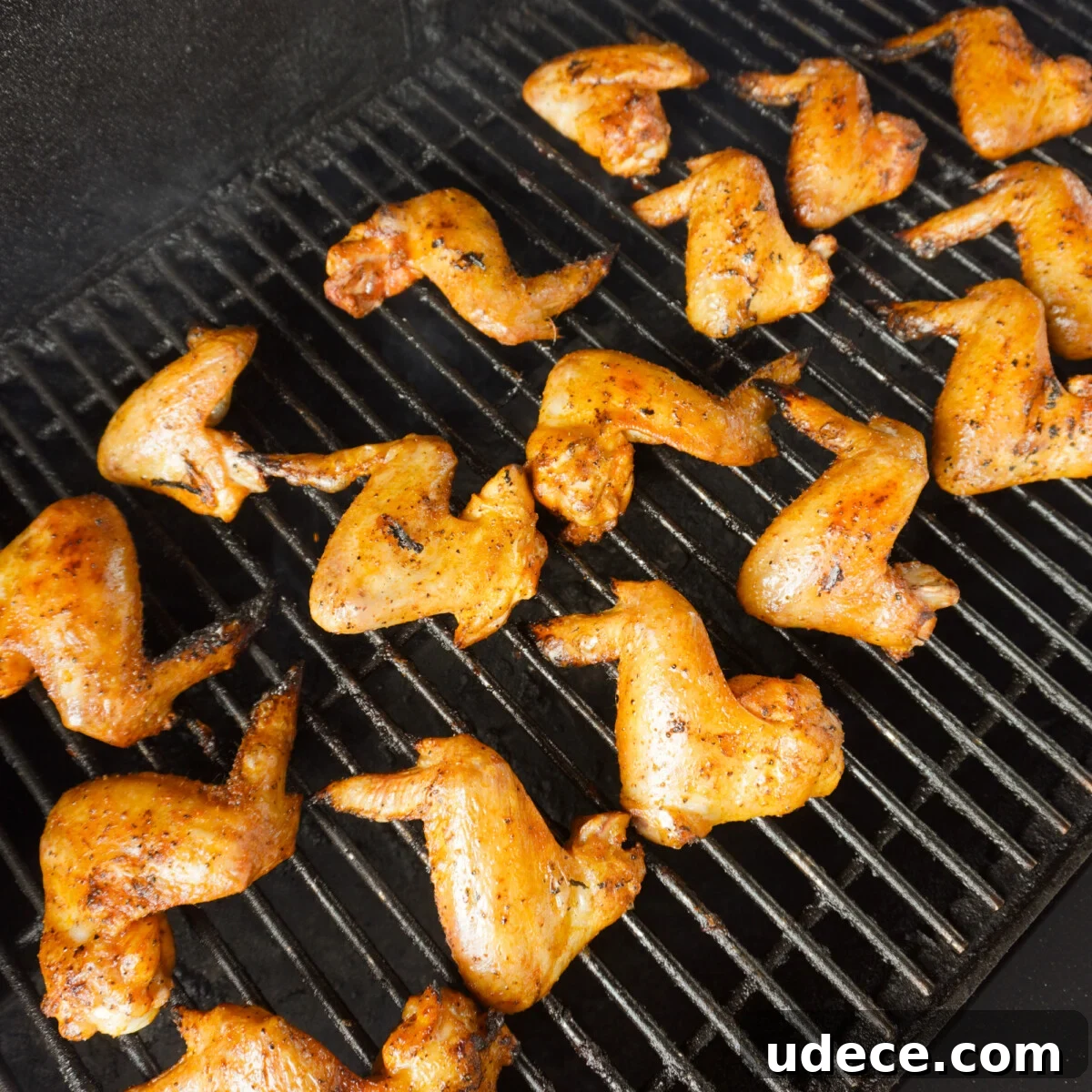 chicken wings being grilled over indirect heat on a grill.