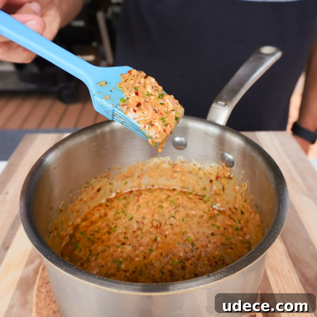 cowboy butter sauce cooked in a sauce pan with a brush showing the consistency.