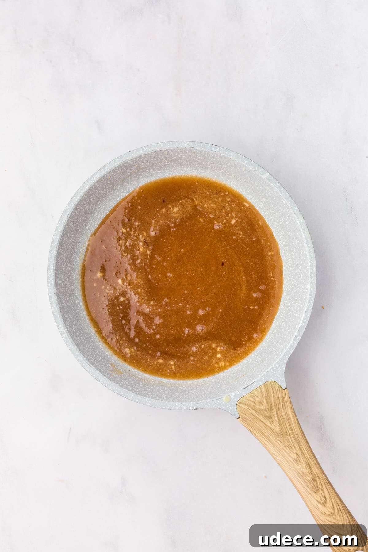 Saucepan filled with melted brown sugar, butter, and honey mixture simmering.