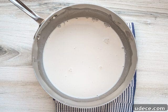Crème Anglaise: Classic French Vanilla Custard Sauce Recipe 3 Creamy sauce cooking in a saucepan.