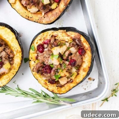Baked acorn squash shown stuffed with sausage and vegetables.