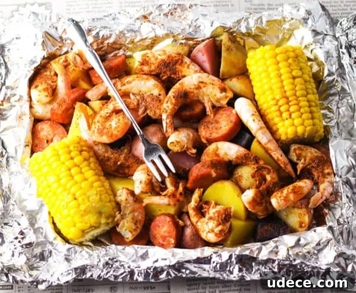 Aluminum foil filled with shrimp, sausage, and corn on the cob.