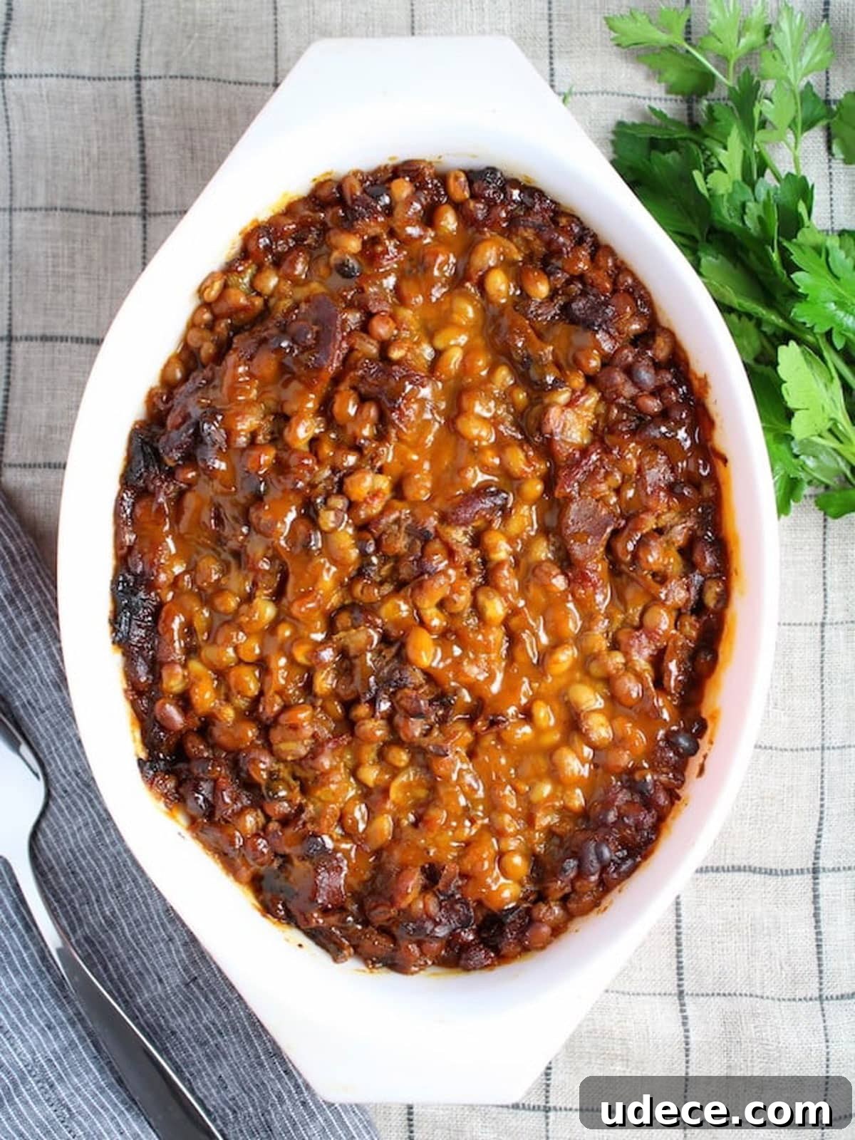 Baking dish filled with baked beans sitting on a counter.