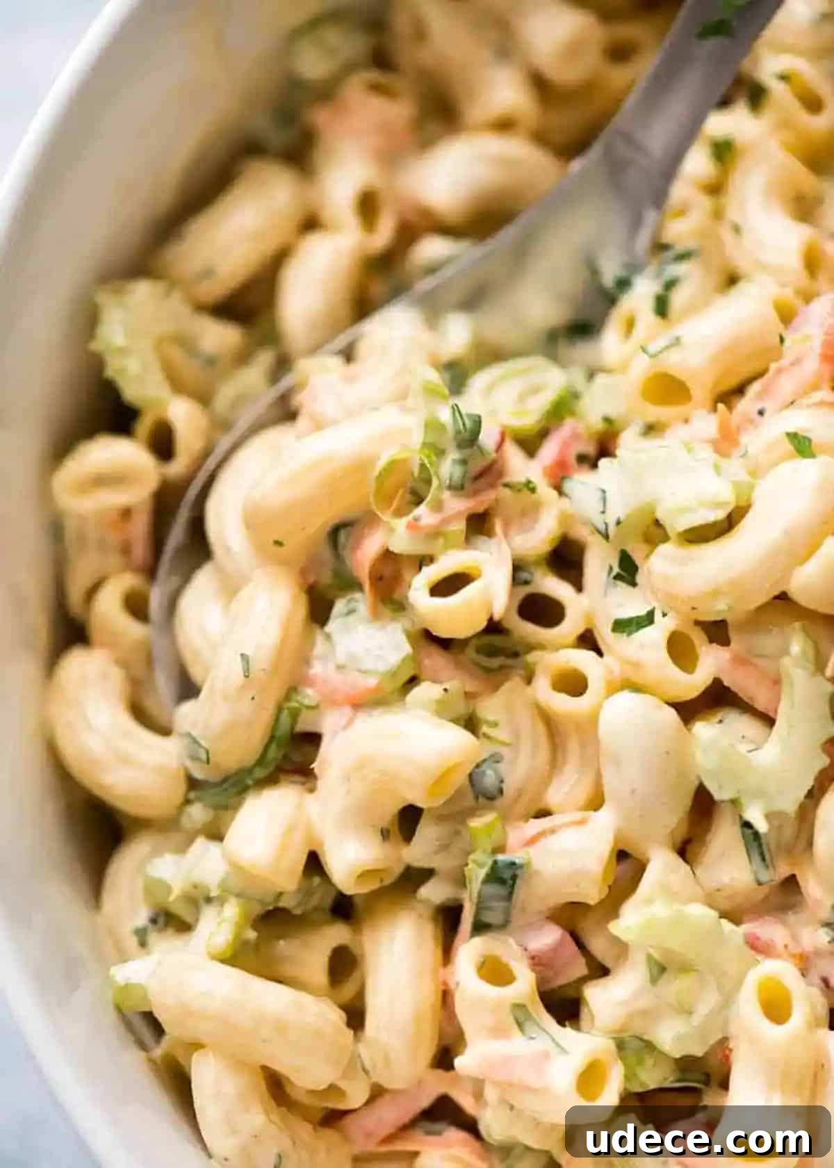 Close up of pasta salad in a bowl covered in dressing.