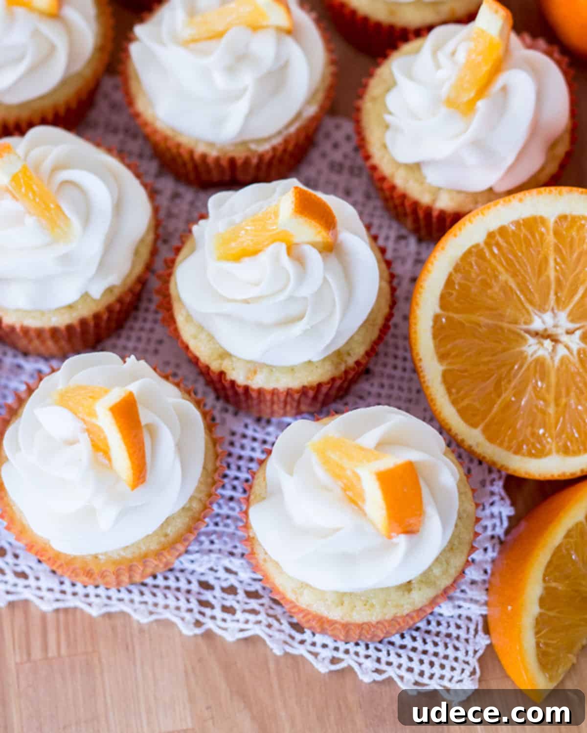 Orange cream filled cupcakes on a table.