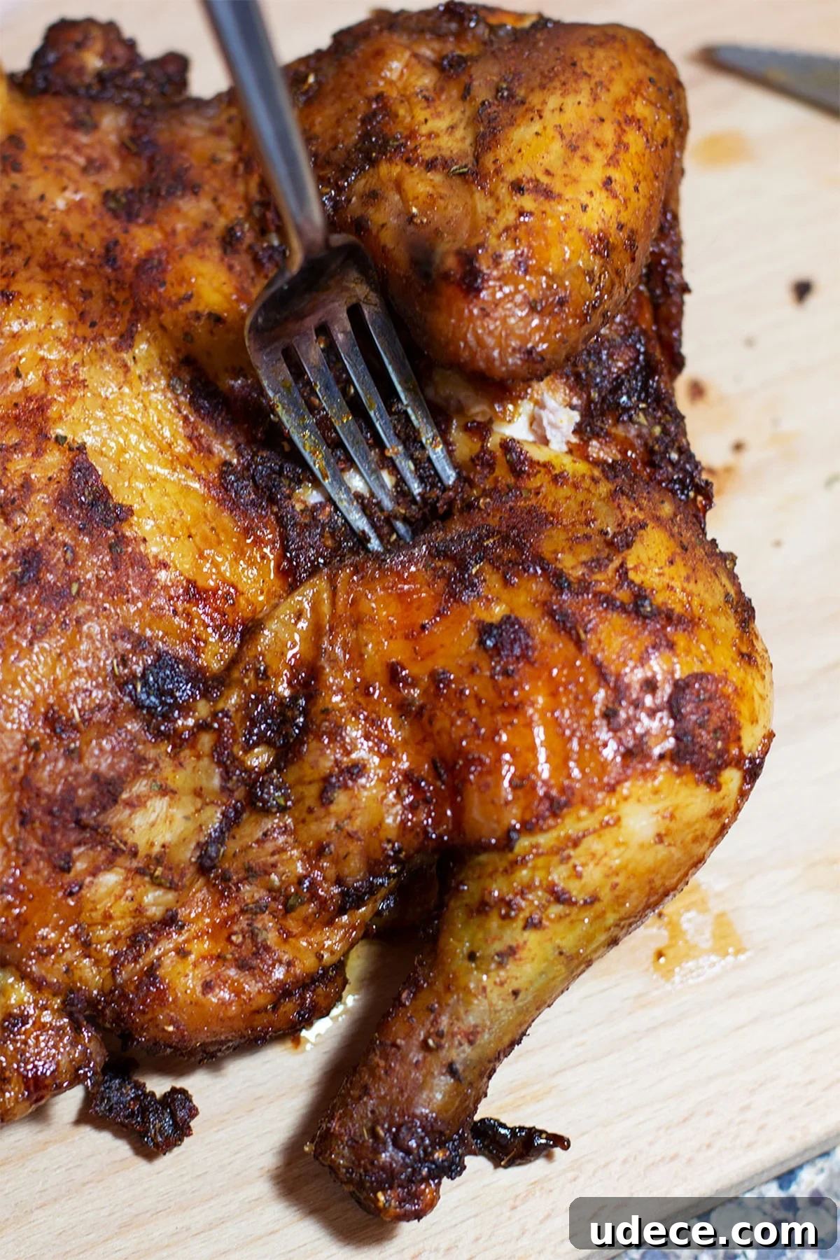 Applewood Smoked Chicken on a wooden cutting board, fork in chicken.