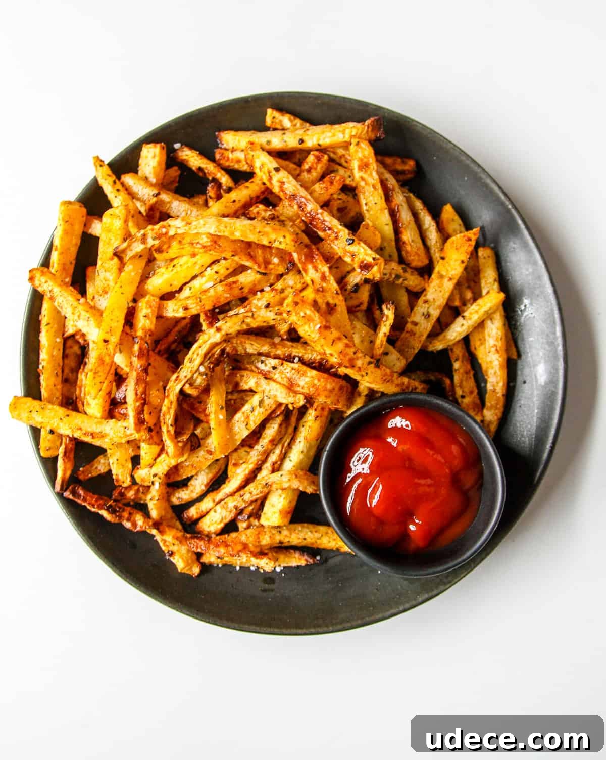 Crispy Air Fryer Rutabaga Fries with Garlic Parmesan Dip 2 A plate of rutabaga fries with a small dish of ketchup.