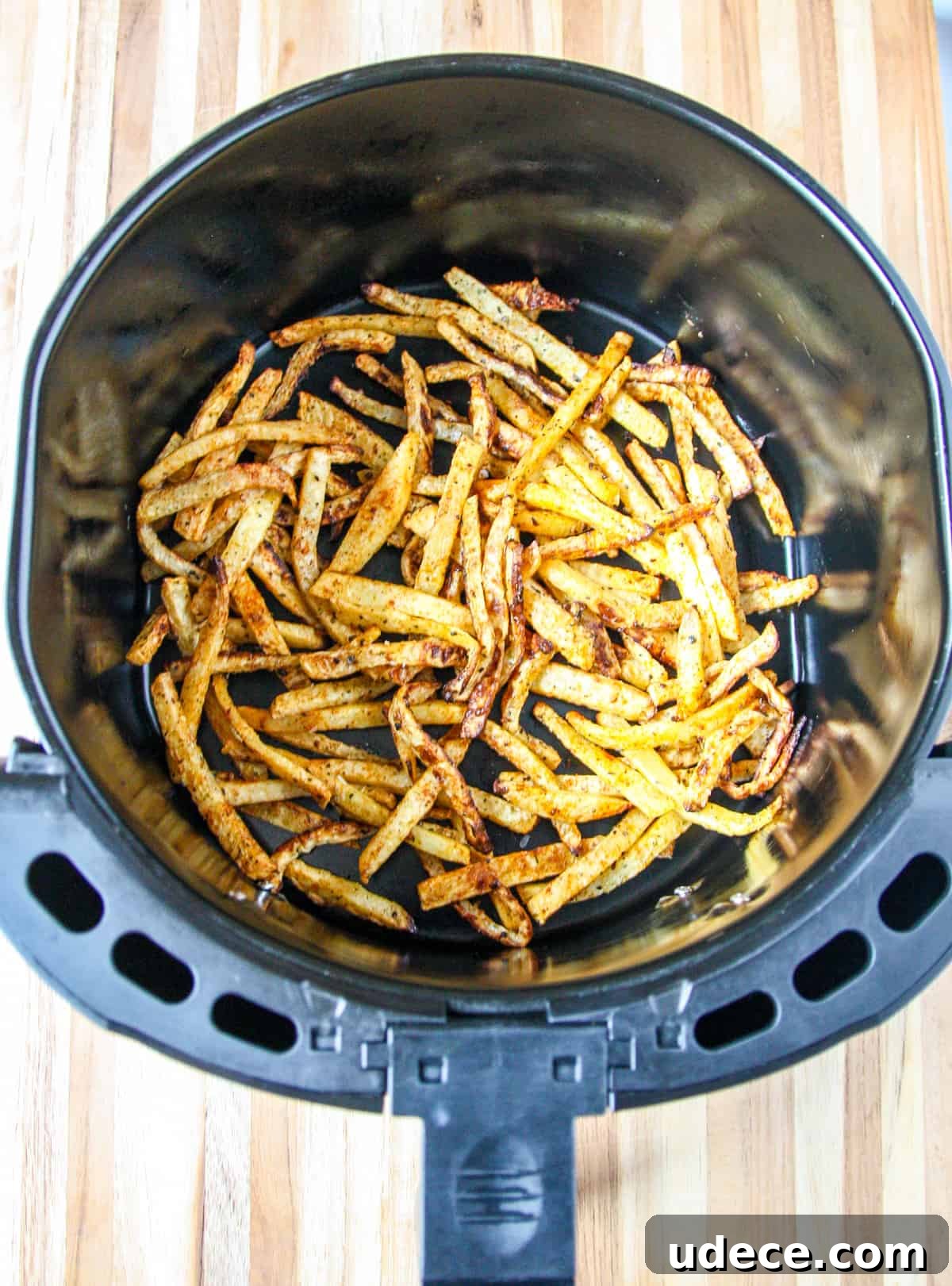 Crispy Air Fryer Rutabaga Fries with Garlic Parmesan Dip 7 Cooked rutabaga fries in an air fryer basket.