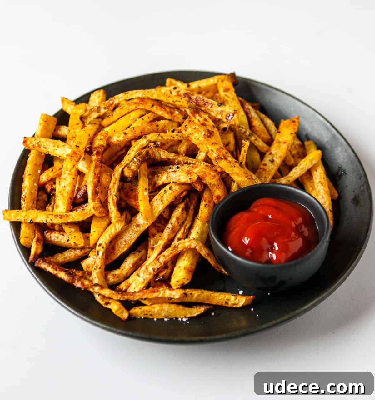 Crispy Air Fryer Rutabaga Fries with Garlic Parmesan Dip 8 A plate full of crisp fries with ketchup.