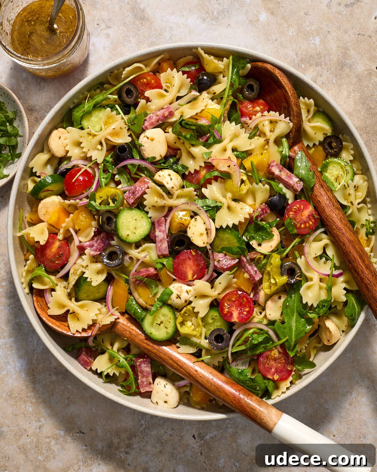 Italian pasta salad in a large bowl with wooden salad servers.