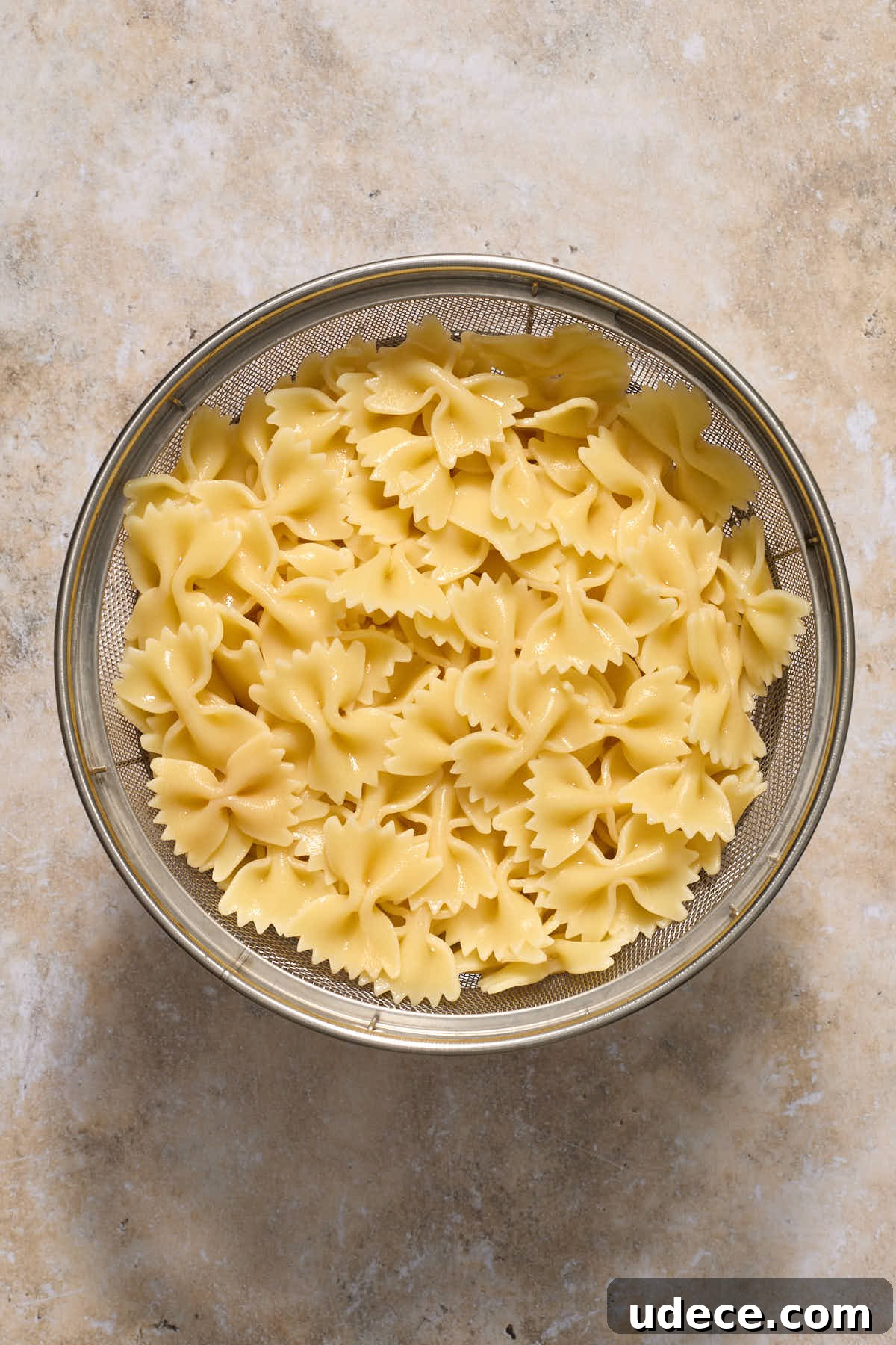 Cooked bow tie pasta in a colander.